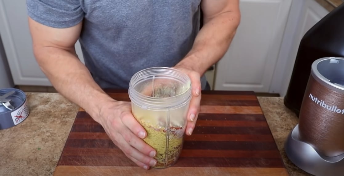 Plant-based nutritionist Derek Simnett using a blender to make a cheesy nutty topping