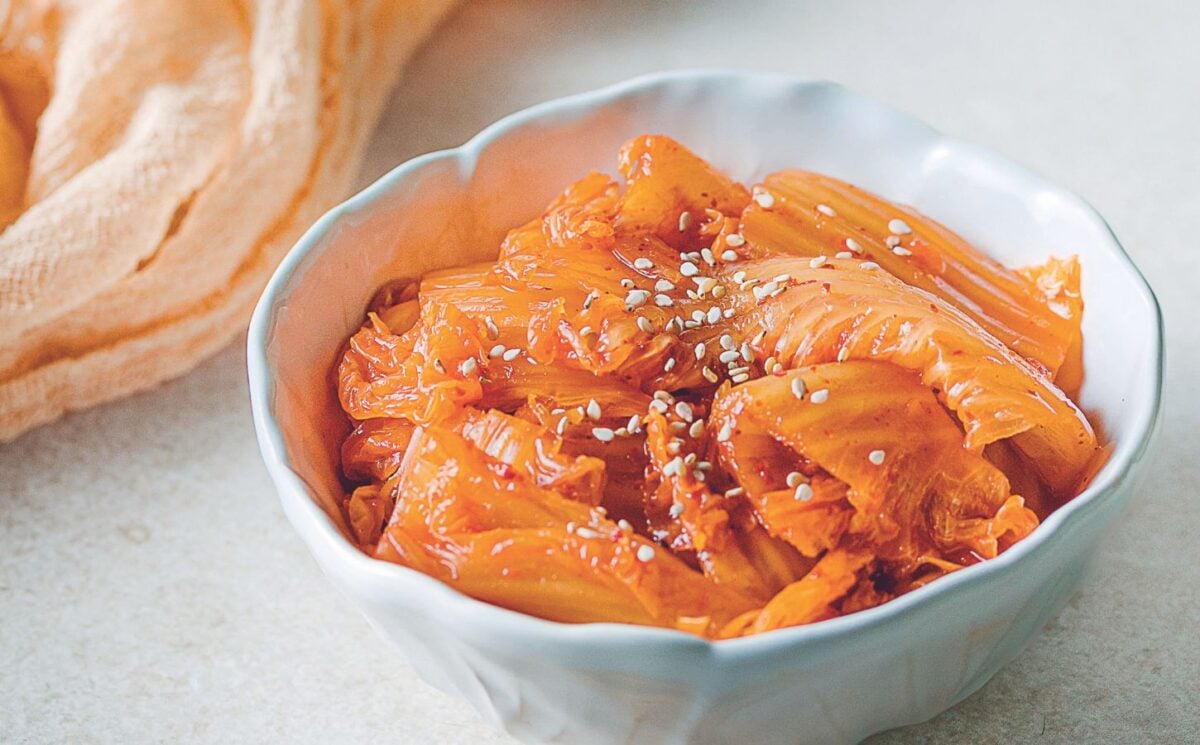 a bowl of vegan kimchi with cabbage, garlic, mushrooms, and Korean chili powder