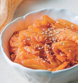 a bowl of vegan kimchi with cabbage, garlic, mushrooms, and Korean chili powder