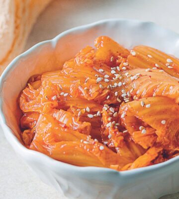 a bowl of vegan kimchi with cabbage, garlic, mushrooms, and Korean chili powder