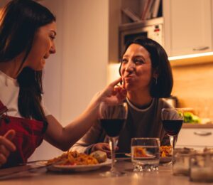 A couple eating a vegan Valentine's meal deal for two with red wine