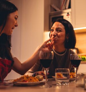 A couple eating a vegan Valentine's meal deal for two with red wine