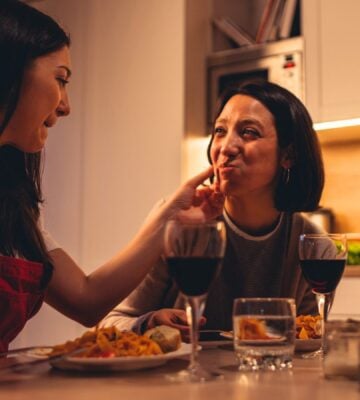 A couple eating a vegan Valentine's meal deal for two with red wine