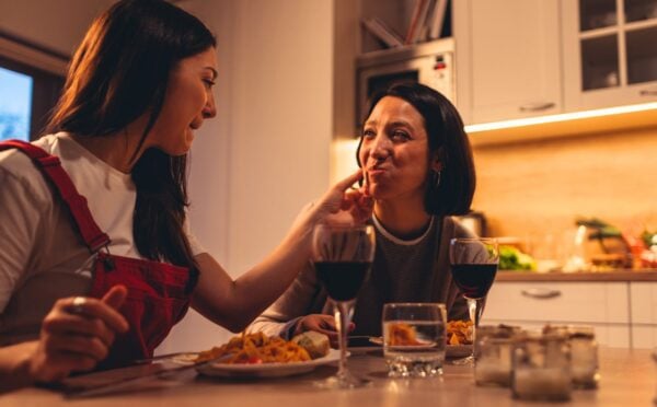 A couple eating a vegan Valentine's meal deal for two with red wine