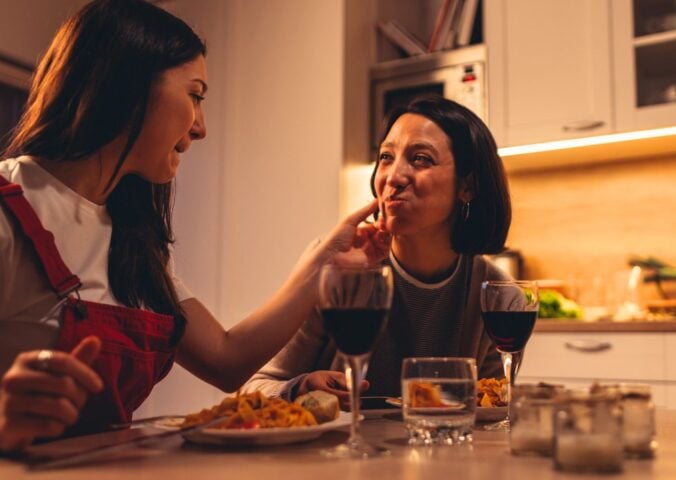 A couple eating a vegan Valentine's meal deal for two with red wine