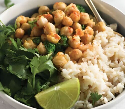 a bowl of warming chickpea coconut curry with cilantro and lime