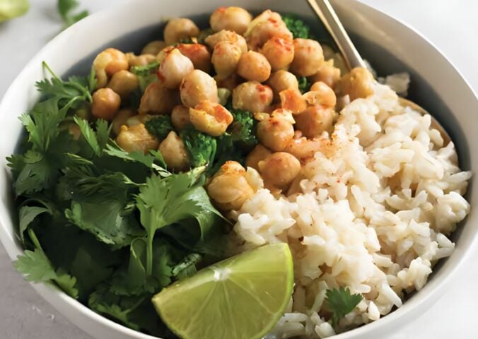 a bowl of warming chickpea coconut curry with cilantro and lime