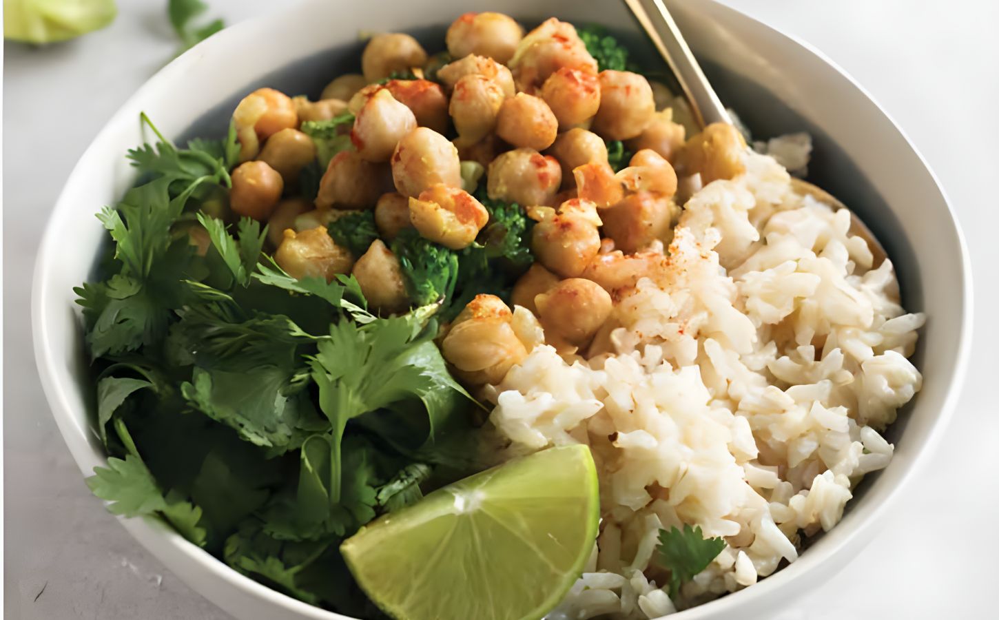 a bowl of warming chickpea coconut curry with cilantro and lime