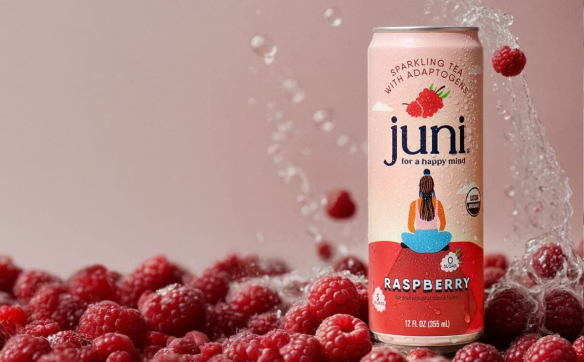 Photo shows a tin of Juni sparkling tea over a layer of raspberries