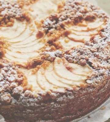 This vegan apple cake is made with cinnamon and topped with apple slices