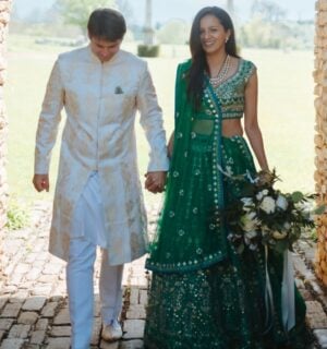 Photo shows Klaus and Kamal walking through a cobbled archway in their wedding outfits