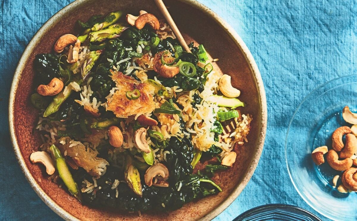 a bowl of crispy rice salad with crunchy vegetables and a side of cashew nuts