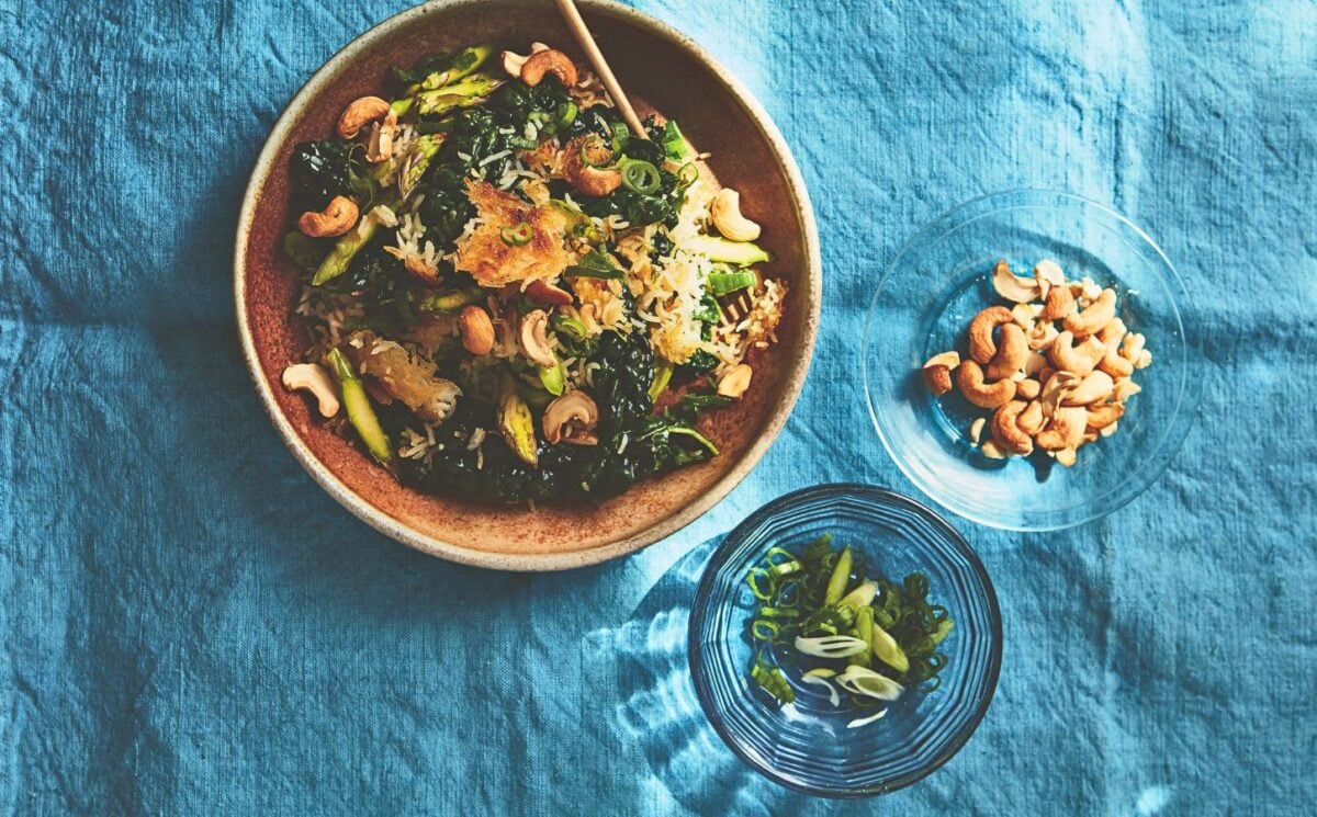 a bowl of crispy rice salad with crunchy vegetables and a side of cashew nuts