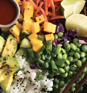 a deconstructed sushi bowl with edamame, avocado, carrot, and mango