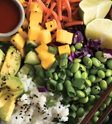 a deconstructed sushi bowl with edamame, avocado, carrot, and mango