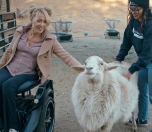 Gretchen Ryan with a sheep at Farm Sanctuary - a still from vegan film "Liberty"