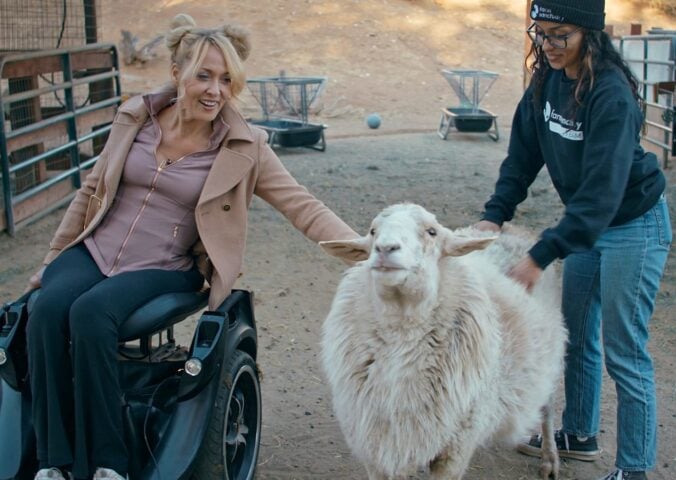 Gretchen Ryan with a sheep at Farm Sanctuary - a still from vegan film "Liberty"