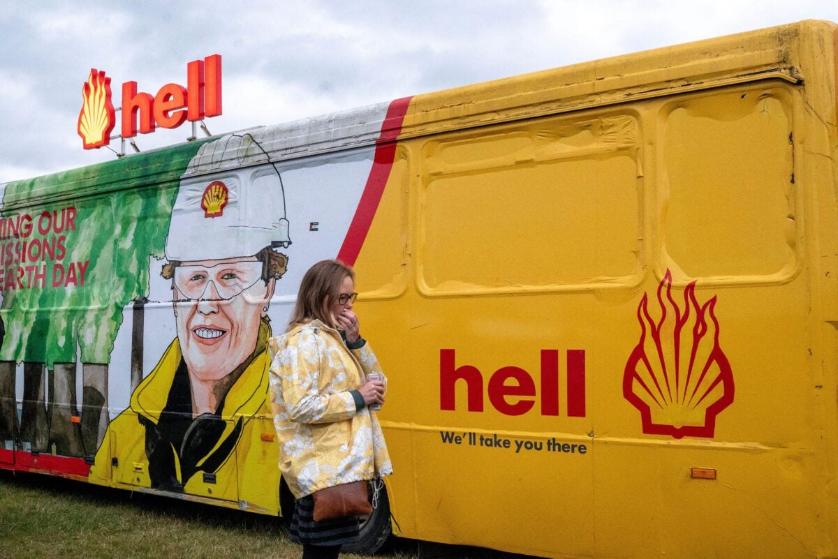 An attendee walks past an anti Shell van at Massive Attack's plant-based Act 1.5 festival