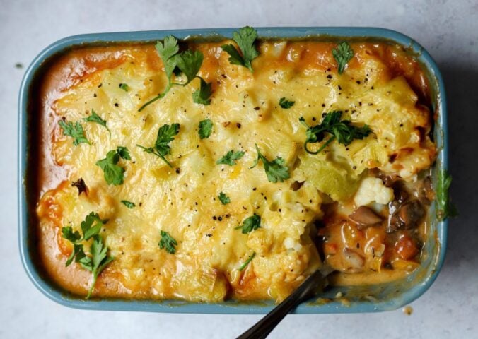 meat-free cottage pie with leek and cauliflower topping plus mushrooms, vegan grated cheese, and herbs