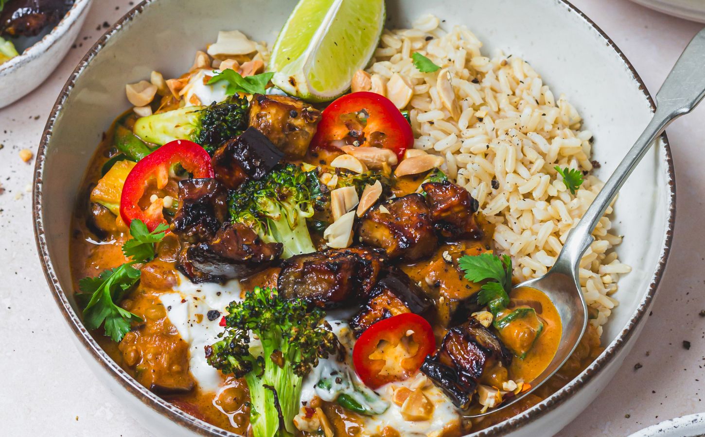 a bowl of roasted aubergine and broccoli lentil curry with brown rice