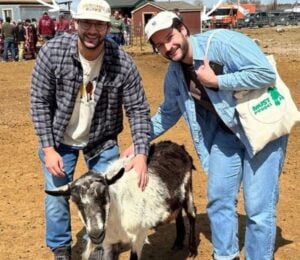 Trupo Treats founders Brian and Charlie Trupo in one of the sanctuaries that they support posing with a goat