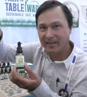 A still from a video from YouTuber John Kohler of OkRaw holding up some of his favorite vegan health products