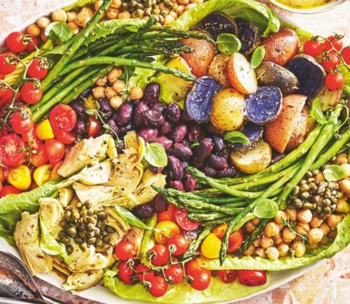 A vegan nicoise salad on a large plate