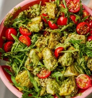 a baked pesto tofu bro bowl with tofu, quinoa, cherry tomatoes and rocket as part of vegan power bowl recipes