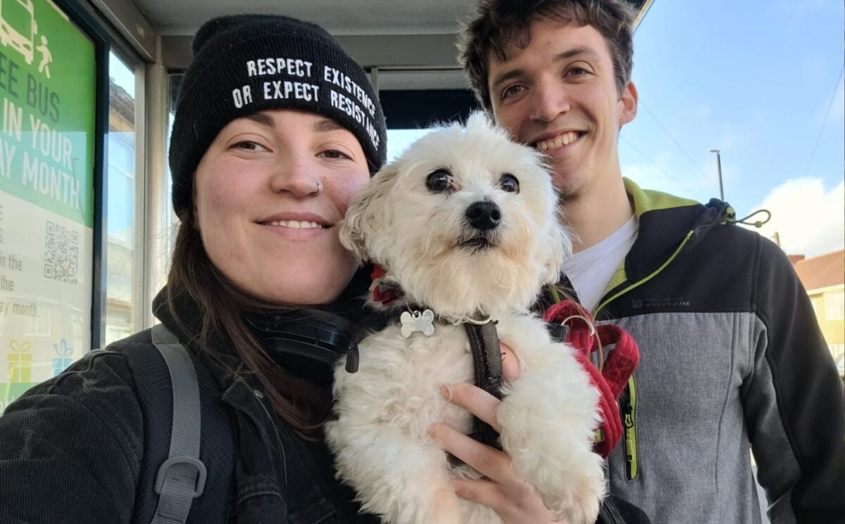 Photo shows Rory and Issy holding up a small white dog