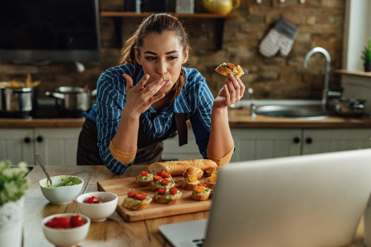 A woman eating some vegan bruchetta