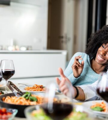 Friends sitting down to eat spaghetti after taking part in Veganuary