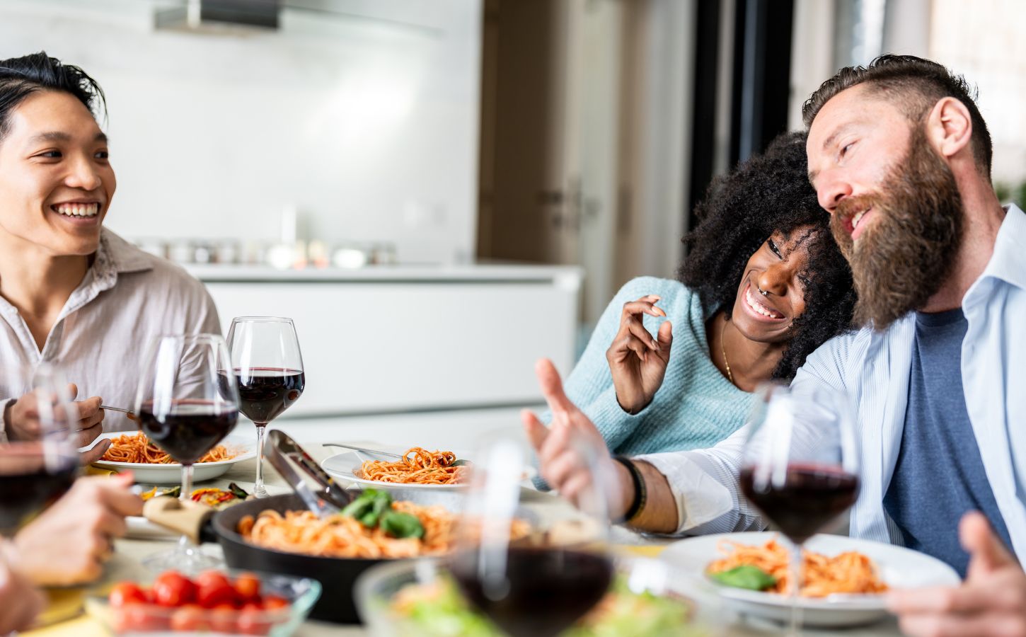 Friends sitting down to eat spaghetti after taking part in Veganuary