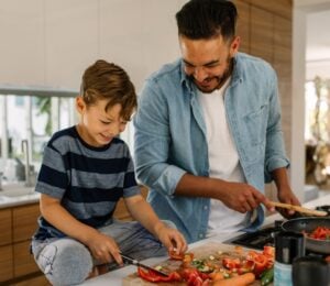 Photo shows a father and son cooking together