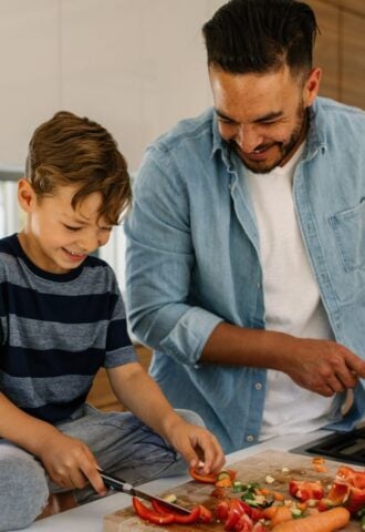 Photo shows a father and son cooking together