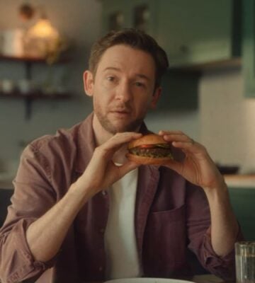 Screengrab from the new Beyond Meat advertisement shows someone eating a plant-based burger in a kitchen