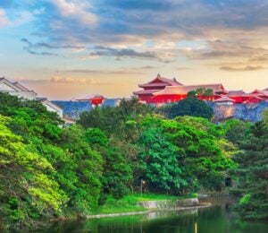 A landscape picture of Blue Zone area Okinawa, Japan, showcasing green trees and red buildings