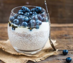 Picture shows a glass cup full of blueberry and chia seed pudding