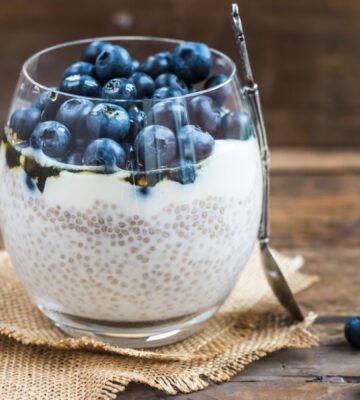 Picture shows a glass cup full of blueberry and chia seed pudding