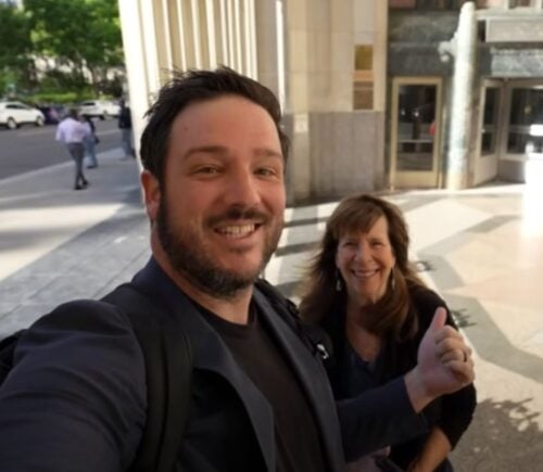 A YouTuber and his mom speaking directly to camera on the street in a video reviewing Eleven Madison Park