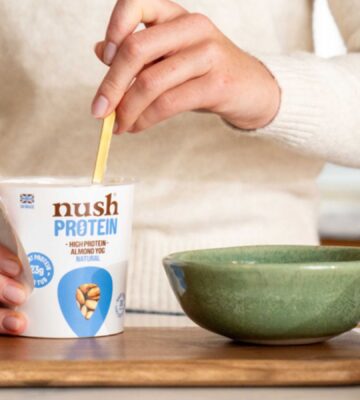 A person spooning a Nush high protein, soy-free yogurt