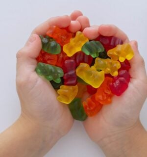 Photo shows a child's hands as he cups jelly beans in the shape of a heart