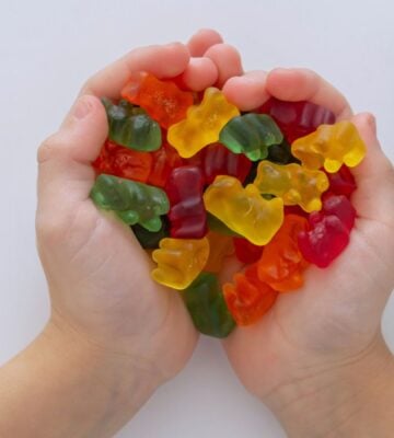 Photo shows a child's hands as he cups jelly beans in the shape of a heart