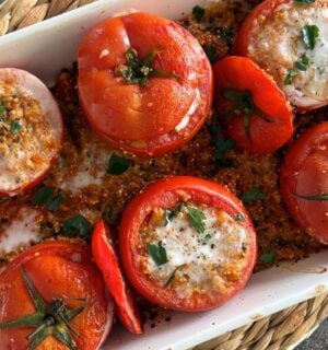 A tray of quinoa stuffed tomatoes with plant-based feta