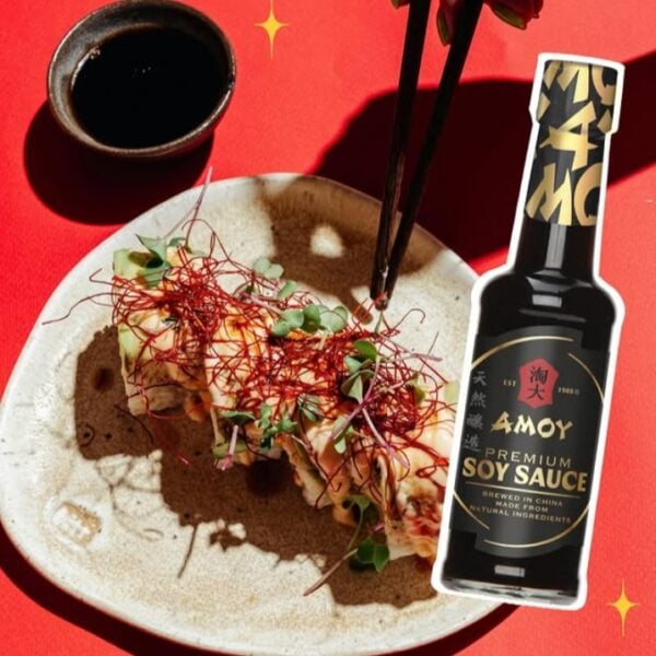 Photo shows a vegetable-based dish next to a cup of soy sauce and a bottle of Amoy's "Premium" soy sauce