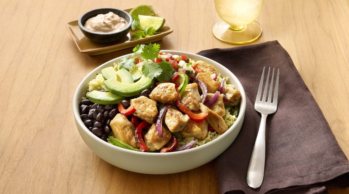 Photo shows a rice bowl-type meal made with avocado, black beans, and vegan Beyond Chicken Pieces