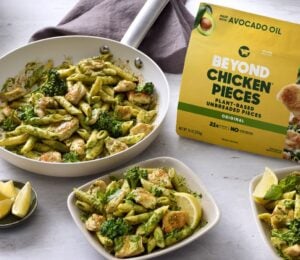 Photo shows several bowls of vegan broccoli pasta featuring the new Beyond Chicken Pieces, alongside the product's packaging