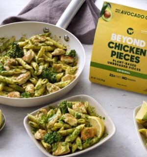 Photo shows several bowls of vegan broccoli pasta featuring the new Beyond Chicken Pieces, alongside the product's packaging