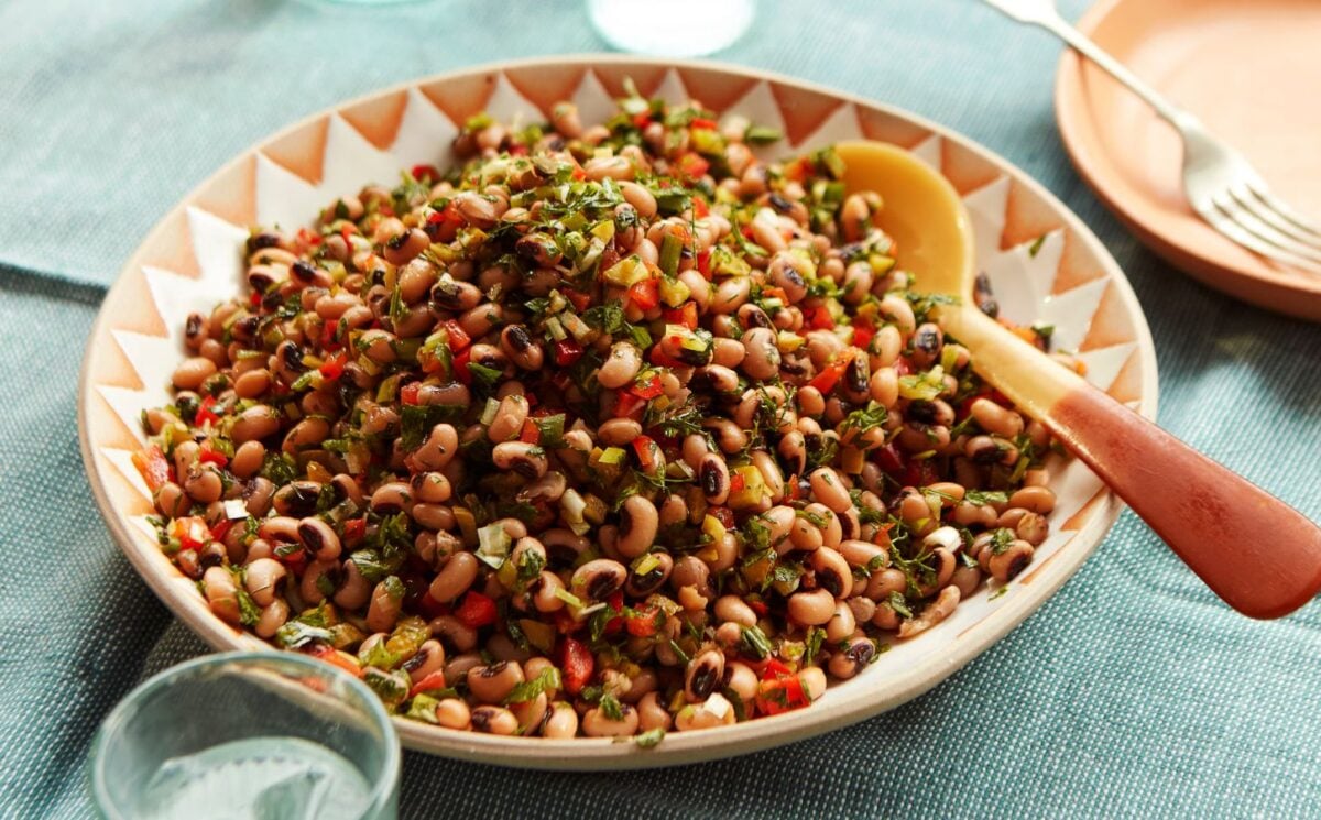 a plate of black-eyed bean salad with onion, bell pepper, and cornichons