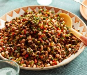 a plate of black-eyed bean salad with onion, bell pepper, and cornichons