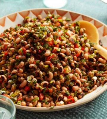 a plate of black-eyed bean salad with onion, bell pepper, and cornichons